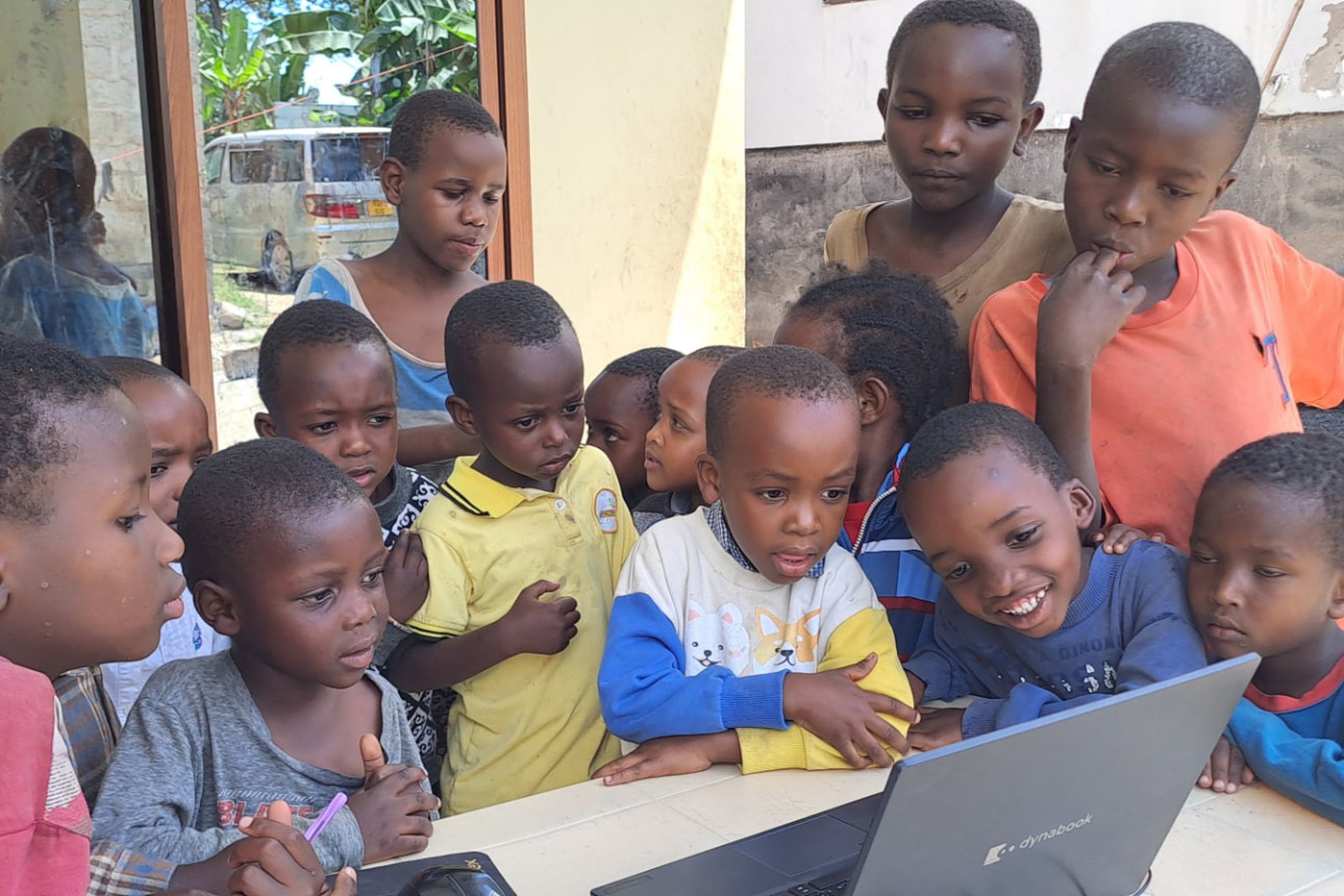 Children learning on a laptop at the Fruitful Orphanage and Day Care Center in Arusha